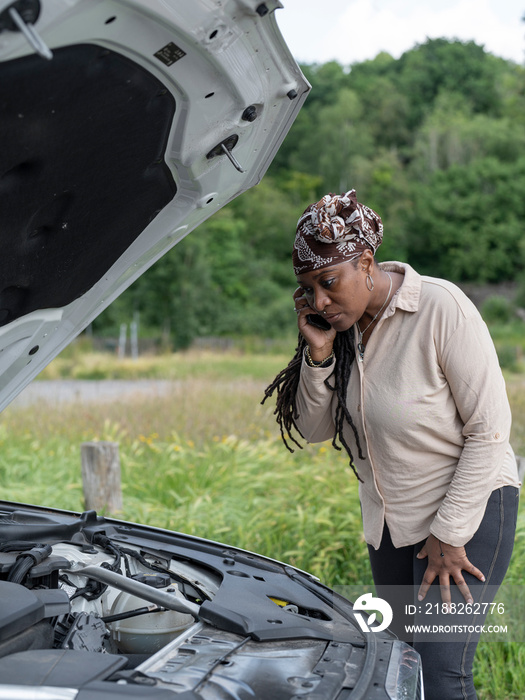 Woman calling roadside assistance for broken-down car