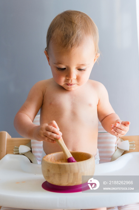 Baby girl about one year eating a carrot with baby led weaning method