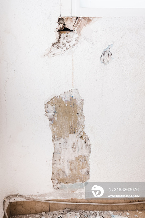 Detail of the damage to a wall inside a house caused by humidity.