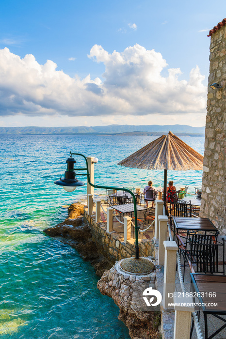 Couple of unidentified tourists sitting in coastal restaurant in Bol town, Brac island, Croatia