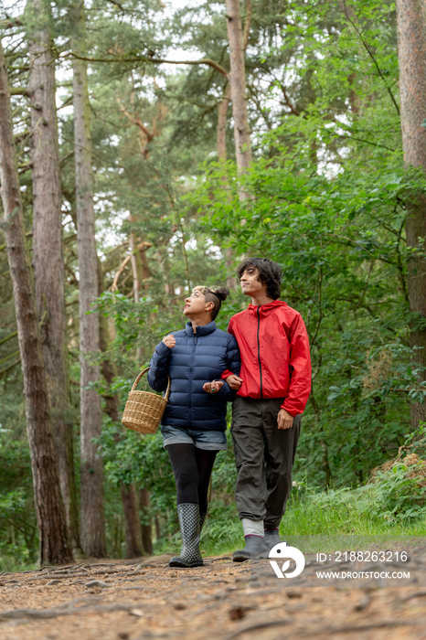 Mother and son walking in forest with basket