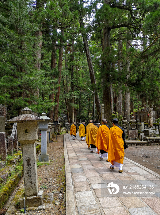 Monks walking on the 2 km long path with ancient tombs in the Okunoin cemetery towards the mausoleum of Kobo Daishi in the Unesco site Koyasan, Japan