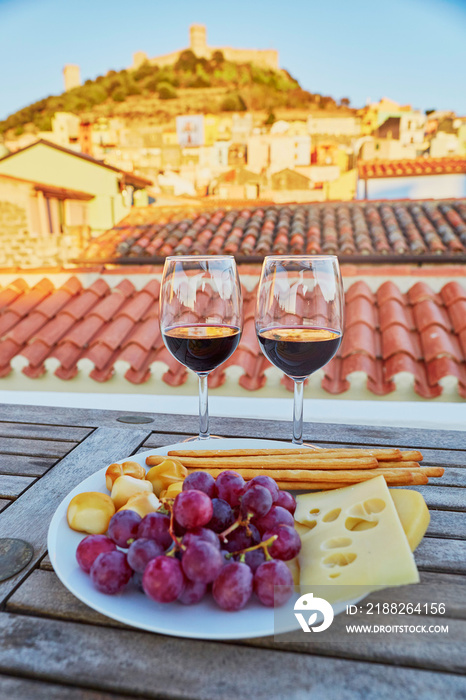 Red wine with delicious cheese, bread and grapes