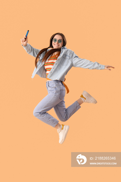 Young woman in sunglasses with disposable electronic cigarette jumping on beige background