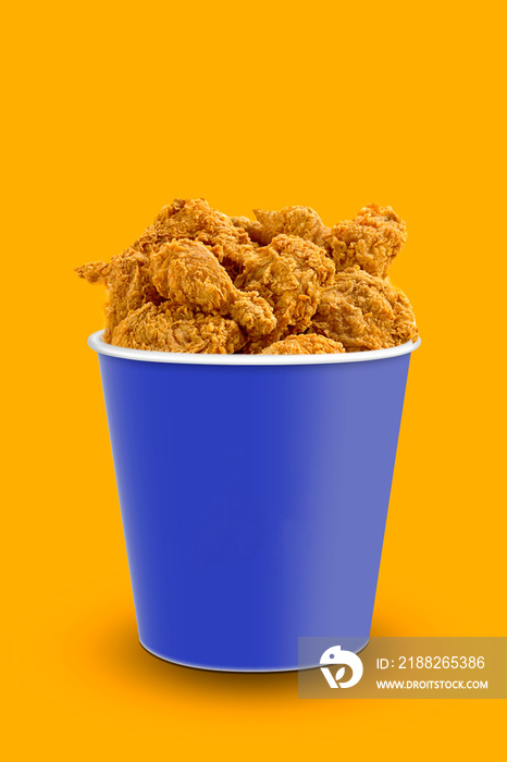 Tasty deep fried chicken pieces on orange background , closeup. chicken bucket. Space for text.