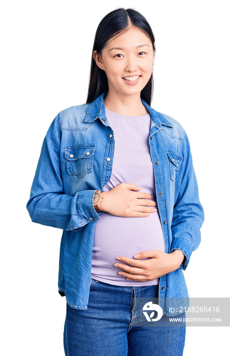 Young beautiful chinese woman pregnant expecting baby with a happy and cool smile on face. lucky person.