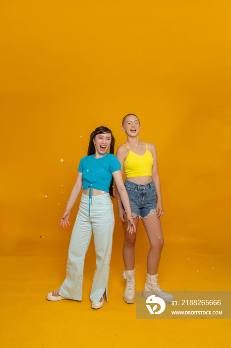 Studio portrait of smiling stylish friends with confetti