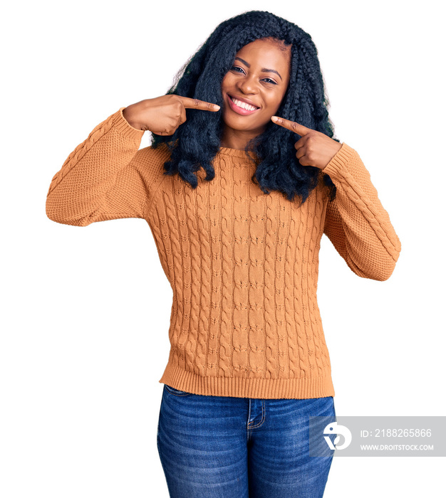 Beautiful african american woman wearing casual  sweater smiling cheerful showing and pointing with fingers teeth and mouth. dental health concept.