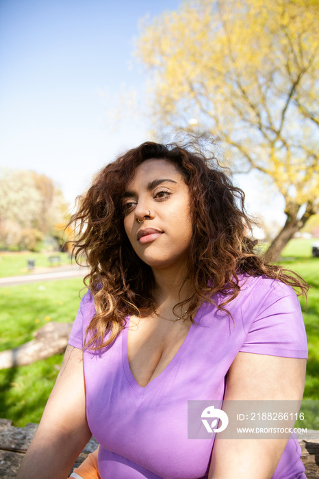 Young plus-sized woman relaxing in the park after workout