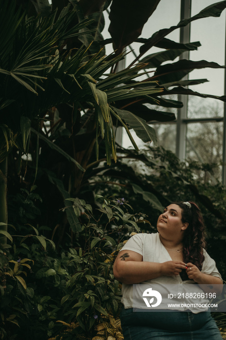 portrait of a plus size woman surrounded by plants