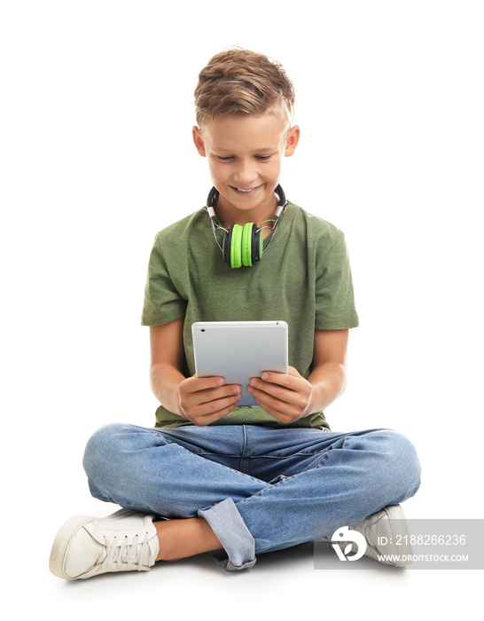 Little boy with headphones and tablet computer on white background