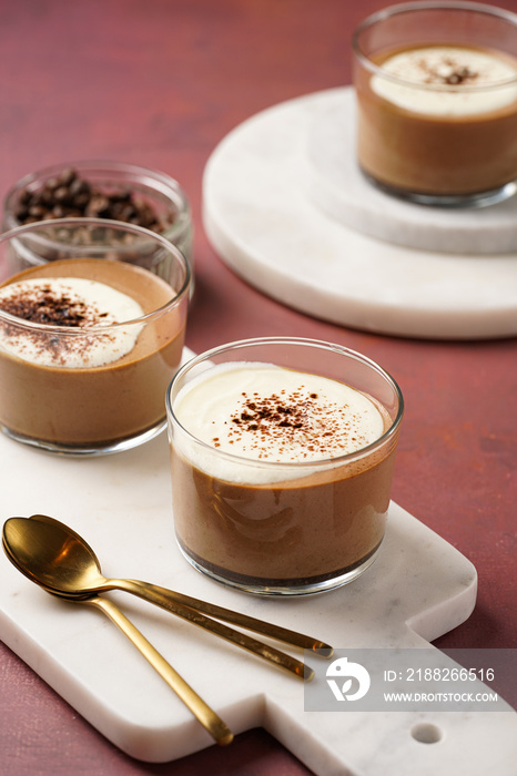 Italian chocolate and coffee mousse dessert semifreddo - half-frozen ice cream with whipped cream and cocoa powder in small glasses on purple surface