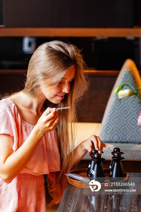 Woman in spa salon chooses the smell of aromatherapy essential oil