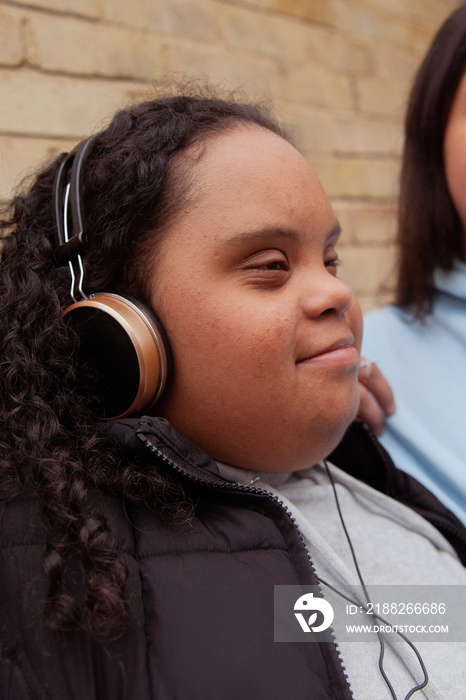 Two plus-sized women with Down Syndrome in workout clothes having fun and listening to music