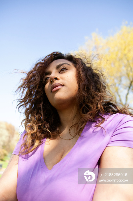 Young plus-sized woman relaxing in the park after workout