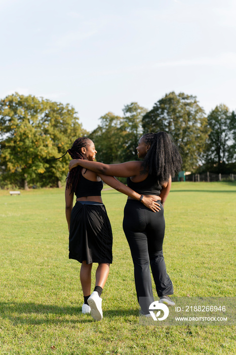 Young female friends walking in park after exercising