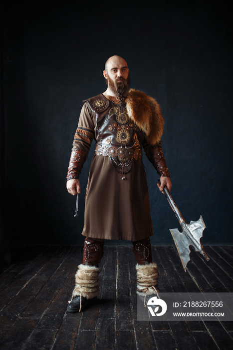Viking with axe in traditional nordic clothes
