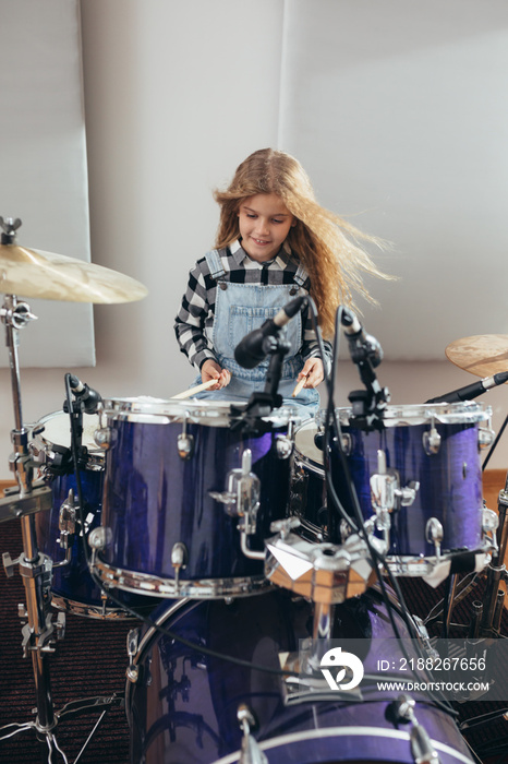 young girl playing drums at the music studio