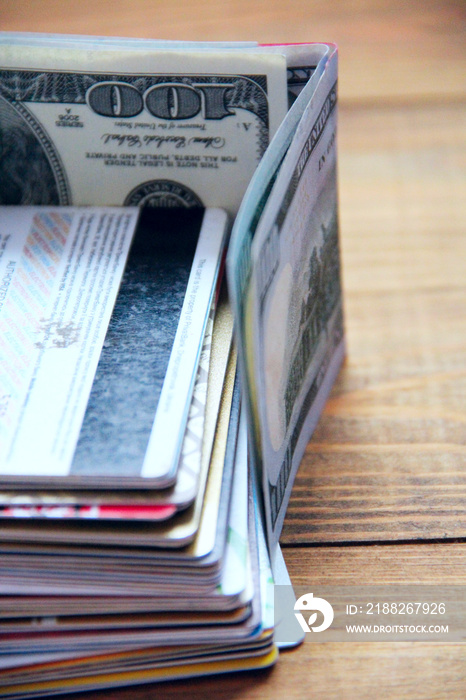 Hundred dollar notes and credit cards. Pile of credit cards fenced in dollars