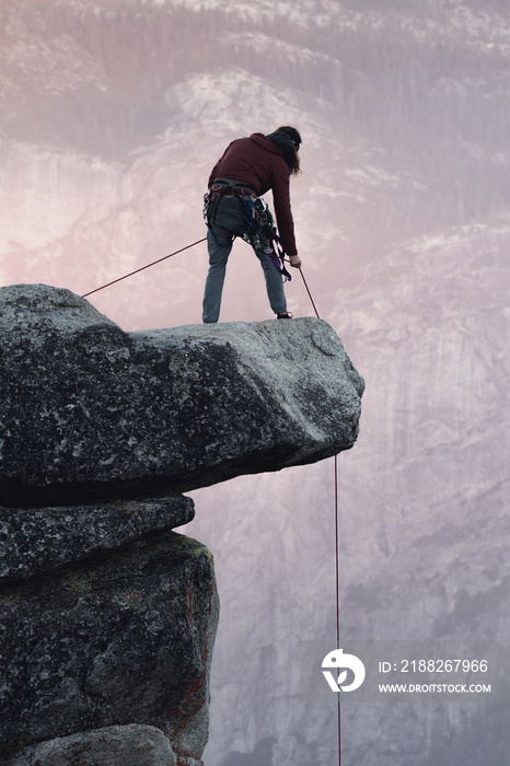 Man prepares to climb from Hanging Rock at sunset in Yosemite