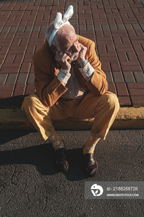 Elderly man in funny suit on pavement stock photo