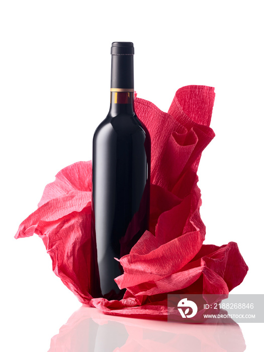 Bottle of red wine with crumpled crepe paper isolated on a white background.