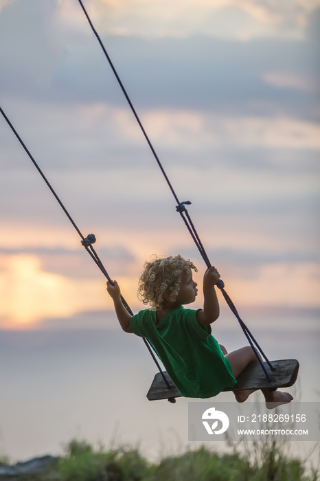 The back of the boys Swings are playing on the beach