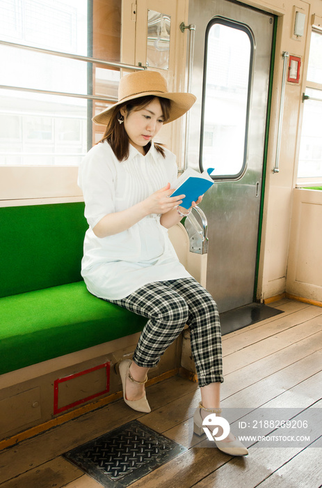 電車内で本を読む女性