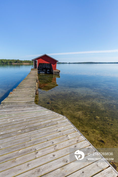 Wooden jetty, boathouse and ocean in Åland Islands, Finland, on a sunny day in the summer.