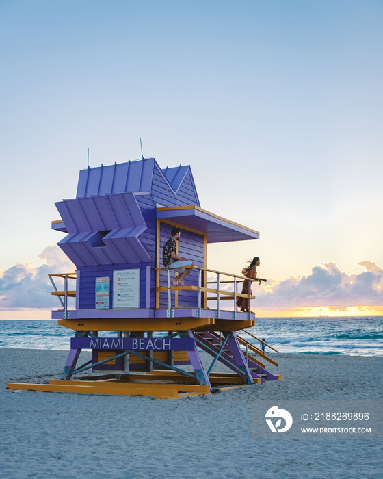 Miami Beach, a couple on the beach at Miami Florida, lifeguard hut Miami Asian women and caucasian men on the beach during sunset