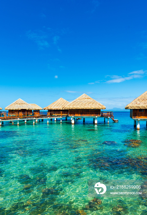 View of the Water Bungalow in the lagoon Huahine, French Polynesia with clear turquoise calm Ocean . Copy space for text. Vertical.