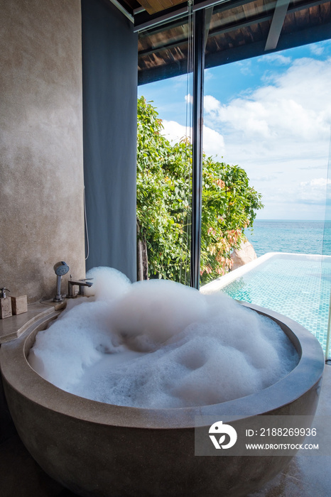 the bathtub with bubble foam against ocean background. Summer, relaxing and vacation concepts