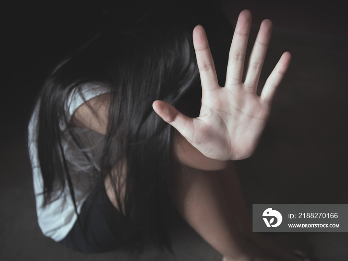 Young girl sitting on the floor with showing stop hand for stop violence and rape,