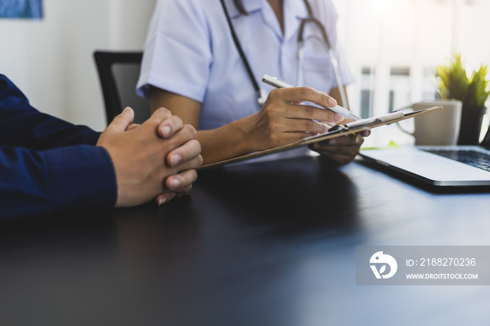 Female doctor fills out a health check-up form while consulting a patient. Medical concepts and health consultations.