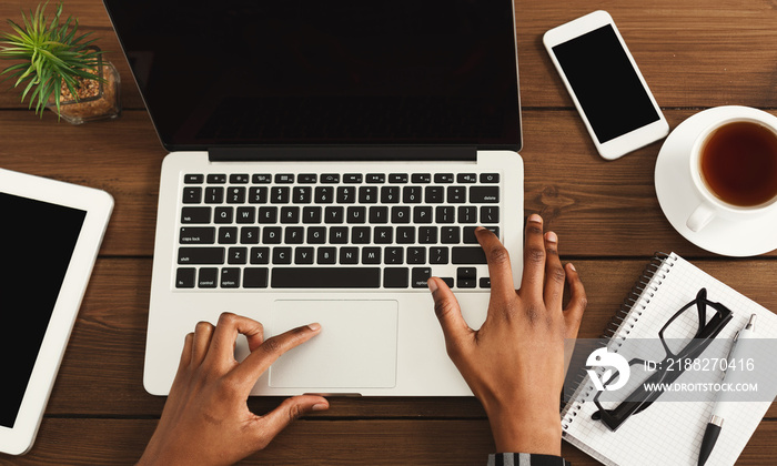 Black female hands on laptop keyboard, top view