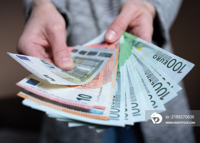 Woman counts money. female hands hold cash banknotes denominations of 5, 10, 100 euro currency. business man rich female hands hold and count, pay cash banknotes euros or paper banknotes