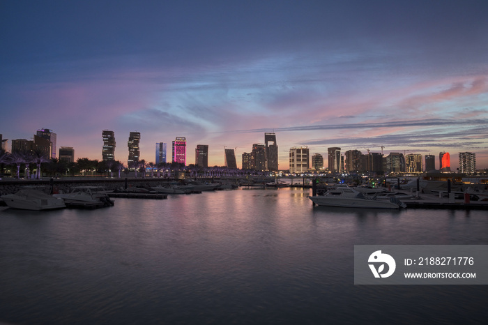 Lusail marina in Lusail city, Qatar at sunset with Yachts and boats ,Lusail skyline and clouds in the sky in  in background