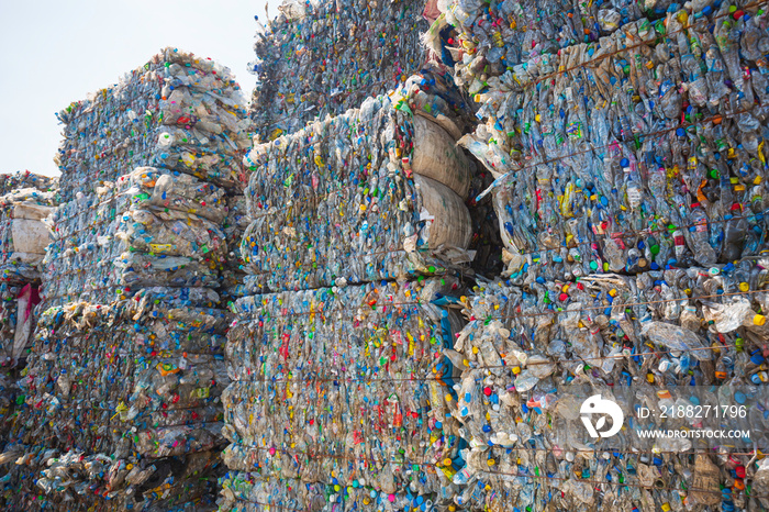 Big pile of waste plastic bottles in the factory to wait for recycling.