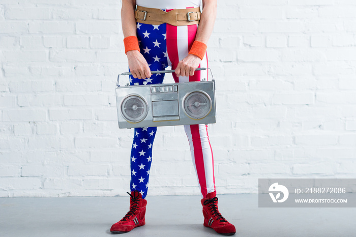 cropped shot of senior woman in patriotic sportswear holding tape recorder