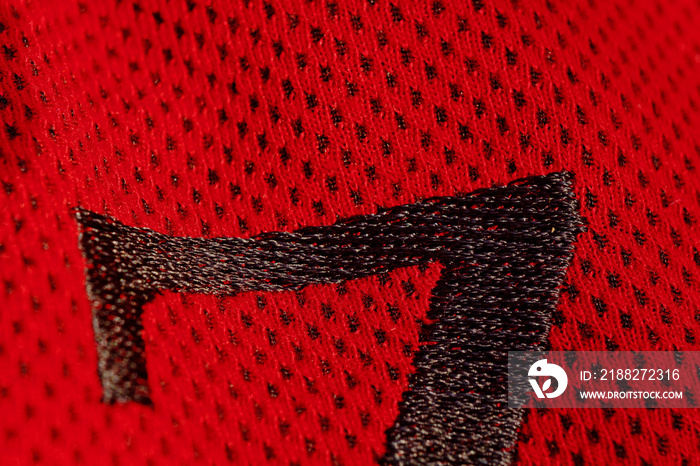 red sportswear closeup top view. embroidered letters on the fabric. breathable knitwear. clothing details macro