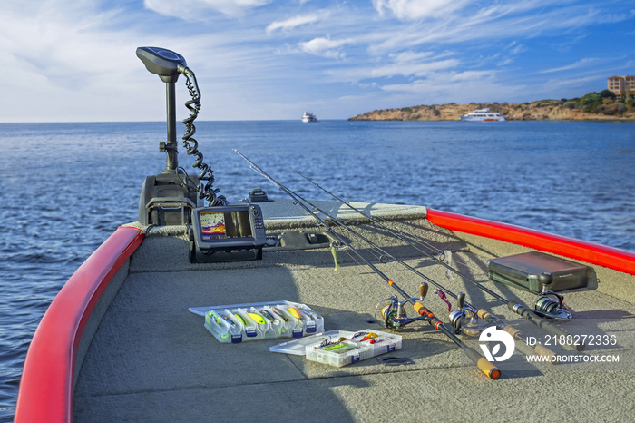 Fishing tackle set and fishfinder, echolot, sonar at the boat. Spinning rods with reels and lures