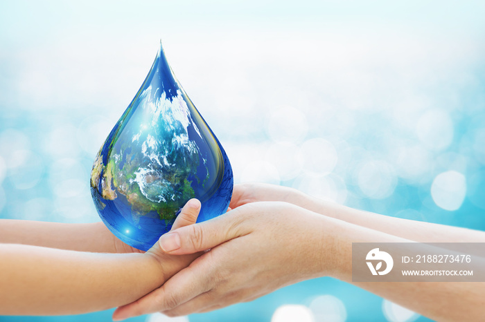 World water day concept . baby Hand and Mom hand Holding Earth in Water Drop shape on Blue Bokeh background.Copy Space on horizontal sheet.Clipping path.Elements of this image furnished by NASA