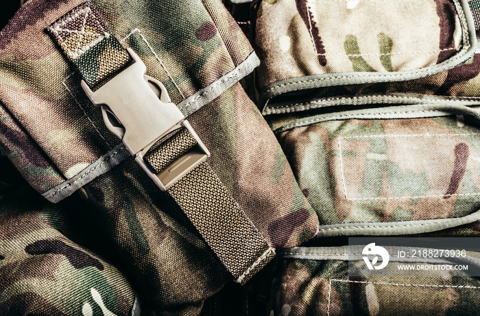 Close-up photo of multi camouflaged soldier vest pouches with lock catch.