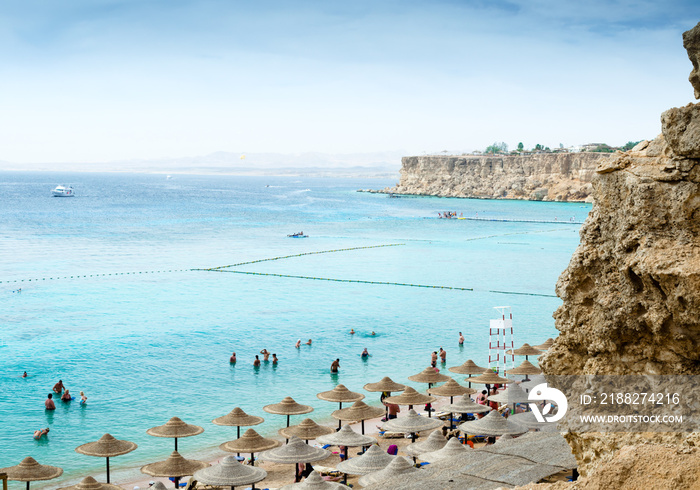 view from the top of the beach with umbrellas of reeds boats and