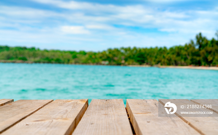 Product display for summer promotion. Wooden bridge on blurred water, coconut tree and sand beach. Empty space for product display montage. Banner for advertise on online media, Business presentation.