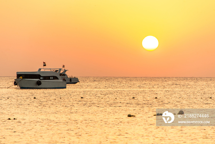 boat silhouetts on the shores of the red sea at sunset in Makadi Bay Egypt golden colors