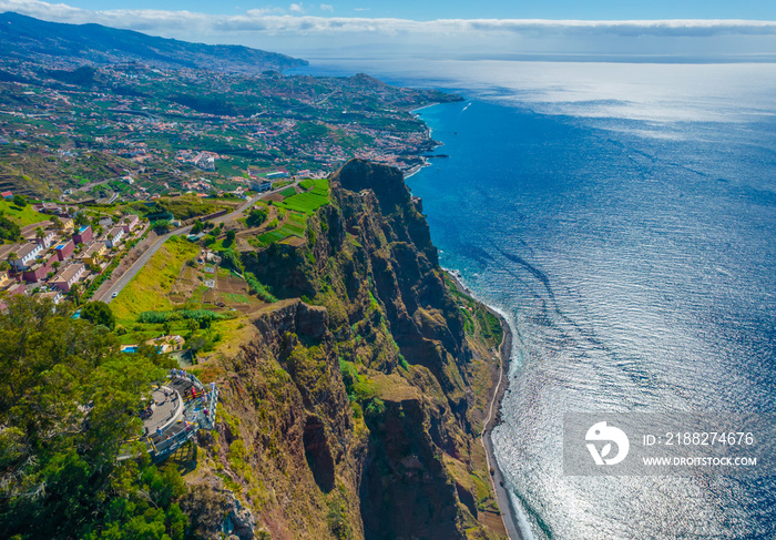 Aerial drone view of Cabo Girao - a lofty sea cliff located along the southern coast of the island of Madeira. The observation view balcony with glass floor with the elevation of 580m