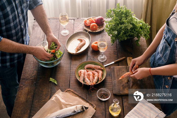 Top view couple cooking together shrimp dinner and vegetables salad