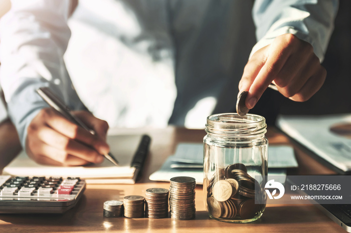 hand holding coins puting into jug glass for saving money. concept finance accounting