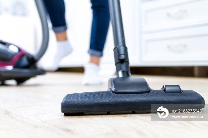 A vacuum cleaner. Room cleaning. Young woman cleaning the floor in the living room with a vacuum cleaner